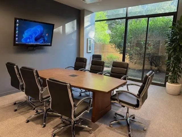 Conference room at The Greenway with large table and TV